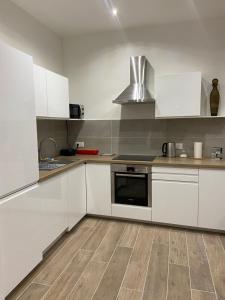 马赛Appartement chic plage des Catalans的厨房配有白色橱柜和炉灶烤箱。