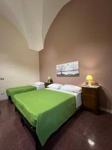 马蒂诺Casa Vacanze Sotto L'Arco的配有绿床单的客房内的两张床