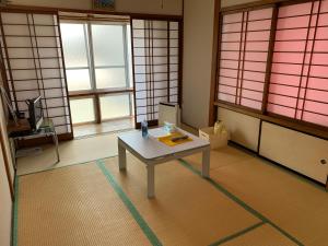 盛冈Buchoho No Yado Morioka的带桌子的客房位于带窗户的房间内