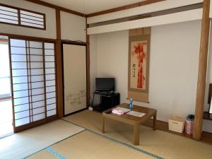 盛冈Buchoho No Yado Morioka的客厅配有桌子和电视