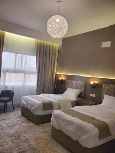 艾卜哈فلل السيف الخاصة的酒店客房设有两张床和吊灯。