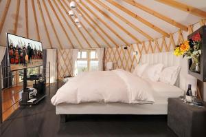 埃米瑞姆甘哈姆拉钦山林小屋的蒙古包内一间卧室,配有一张白色的床