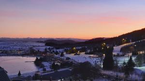 贝斯和圣阿纳斯泰斯Un petit coin de paradis à Super Besse的日落时分雪地中滑雪胜地的景色