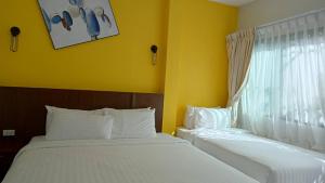 班奥南矛Blue Orchid Beach Krabi - SHA Certified的配有两张床的客房,设有黄色的墙壁和窗户
