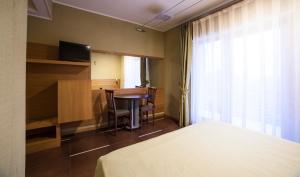 圣乔瓦尼·罗通多Hotel Villa San Pietro的配有一张床、一张桌子和一张桌子的酒店客房