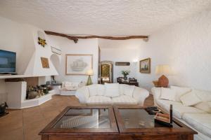 切尔沃港Appartamento Porto Cervo Marina View的客厅配有白色沙发和玻璃桌