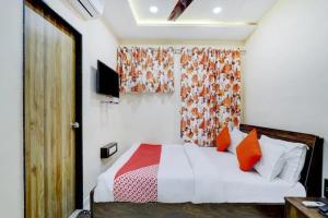 拉杰果德Hotel Blue Leaf的一间卧室配有带橙色和红色枕头的床