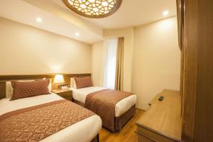 科尼亚奈伊酒店的酒店客房设有两张床和窗户。