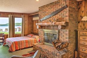 格伦阿伯Rustic Glen Arbor Gem Patio, 4 Mi to Beach!的客厅设有砖砌壁炉和1张床