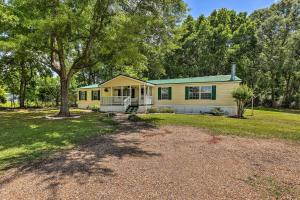 LivingstonCharming Countryside Home with Covered Porch!的院子里有树的黄色房子