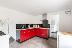 凯恩Le Rethel的一间厨房,配有红色橱柜和白色的墙壁