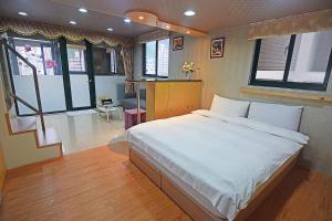 礁溪礁溪玥湯溫泉旅店的一间带一张大床的卧室,位于带窗户的房间内