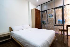 胡志明市Homestay TITO的卧室设有白色的床和大窗户