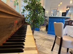 佩兹纳斯莫里哀格兰德酒店的餐厅的钢琴,配有两把椅子和一张桌子