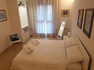 罗维戈ALL'ANTICO CAMPANILE的卧室配有白色床、镜子和毛巾
