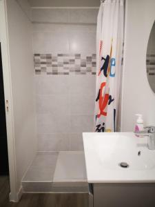Saint-Mitre-les-RempartsL'Olivier的带淋浴和盥洗盆的白色浴室