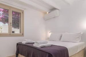 阿达玛斯Gazia Guesthouse Milos的白色卧室,配有带毛巾的床