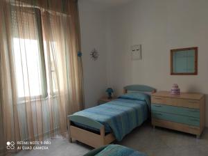 奥里斯塔诺Sardinia ovest的一间卧室配有一张床、一个梳妆台和一扇窗户。
