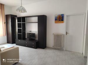 奥里斯塔诺Sardinia ovest的一间带电视和黑色橱柜的客厅