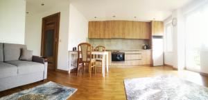 苏瓦乌基Apartament Korczaka Centrum的带沙发和桌子的客厅以及厨房。