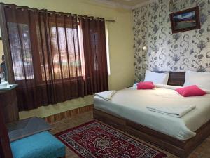 斯利那加Hotel curio's All seasons的一间卧室配有一张带红色枕头的床