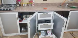 胡塞马appartement boukidan的厨房柜台配有白色抽屉和水槽