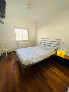 阿尔沃尔Apartamento Praia do Vau的一间卧室配有一张铺有木地板的床和窗户。