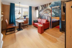 诺德奈neyland apartments Norderney的客厅配有红色的沙发和桌子