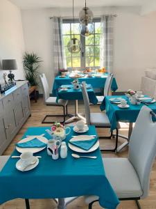 PomportLes Grands Bois的用餐室配有蓝色桌子和白色椅子