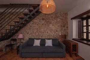 利亚内斯Apartamentos Rurales Playas De Niembro的带沙发和砖墙的客厅