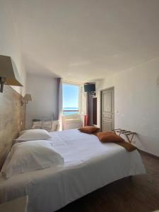 Rogliano尤桑塔涅鲁酒店的窗户客房内的一张大白色床