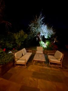 Rogliano尤桑塔涅鲁酒店的晚上花园内摆放着两把椅子和一张桌子
