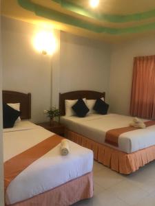 Baan Khai太阳海度假酒店的两张位于酒店客房的床,配有两张sidx sidx单人床