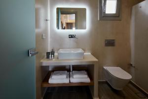 卡马利阿克洛珀旭日酒店的一间带水槽、卫生间和镜子的浴室
