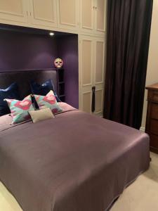 伦敦Charming and full of character的一间卧室设有一张紫色墙壁的大床