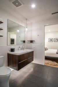 阿什维尔Elevation Lofts Hotel的一间带水槽和卫生间的浴室以及一张床