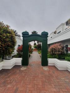 鲸湾港朗霍尔姆酒店的砖路中间的绿色拱门