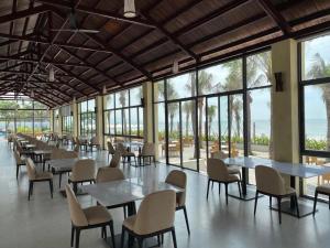 盛日社Aria Resort Vũng Tàu的用餐室设有桌椅和窗户。