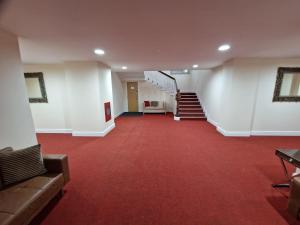 罗奇代尔Birch Hill Clock Tower的走廊上铺有红色地毯,设有楼梯