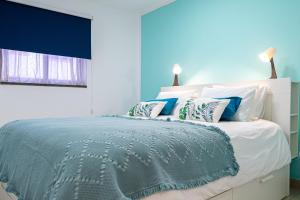 科拉雷侯Dimore Italiane - Boutique Apartments的蓝色卧室配有一张带枕头的大床