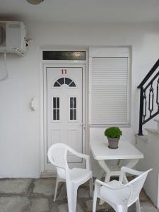 利迈纳里亚Villa Chrissa的配有桌子和两把白色椅子的白色门
