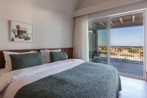斯基罗斯岛ALERÓ Seaside Skyros Resort的一间卧室设有一张床和一个大窗户
