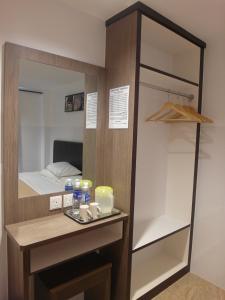 马六甲舒适图恩酒店的更衣室配有镜子和床