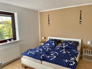 StelleAnkerplatz - Ferienwohnung am Elbdeich的一间卧室配有一张带蓝色和白色枕头的床