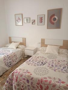 RafelcoferCasa Cerca de Playa Gandia , Denia , Oliva y Benidorm的卧室配有两张床,墙上挂有图片