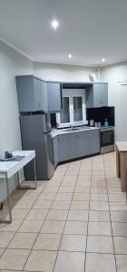 干尼亚Nina Apartment的一间设有白色橱柜和瓷砖地板的大厨房