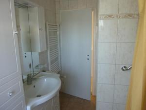 海利根达姆Kleine Sandburg Heiligendamm的白色的浴室设有水槽和淋浴。