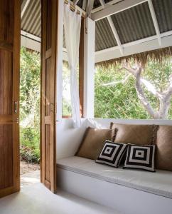 恰洛克拉姆Coconut Beach Bungalows的窗户客房内的沙发