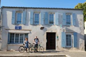 马雷讷Logis des Lauriers Roses的两个人在大楼前骑着自行车