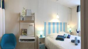 马雷讷Logis des Lauriers Roses的一间小卧室,配有一张床和一张蓝色椅子